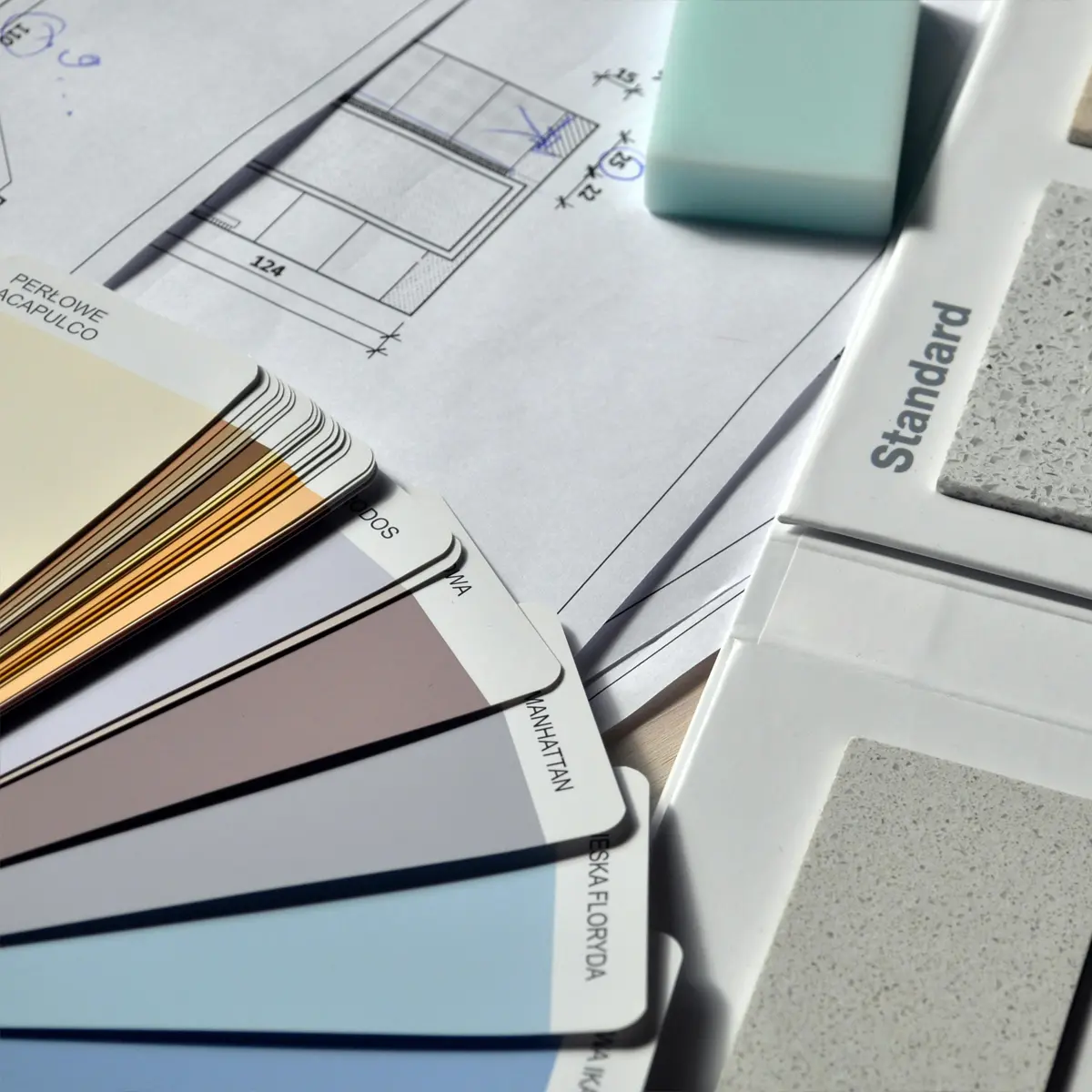 Una mazzetta colore, un catalogo di piastrelle e un progetto architettonico